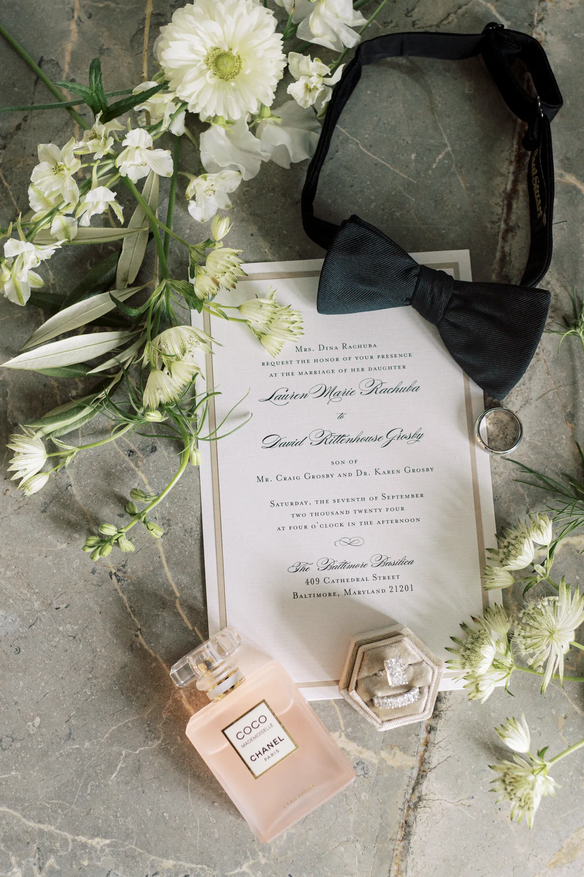 Classic printed wedding invitation styled with flowers and formal accessories